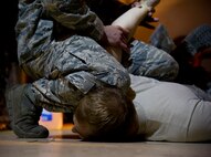 Staff Sgt. William Mack, 91st Security Support Squadron tactical response force member demonstrates how to restrain an aggressor during the 91st SSPTS TRF tryouts at Minot Air Force Base, N.D., Oct. 29. The Tactical Response Force is a nuclear special weapons and tactics team specializing in recapture and recovery operations. (U.S. Air Force photo/Senior Airman Brittany Y. Auld)