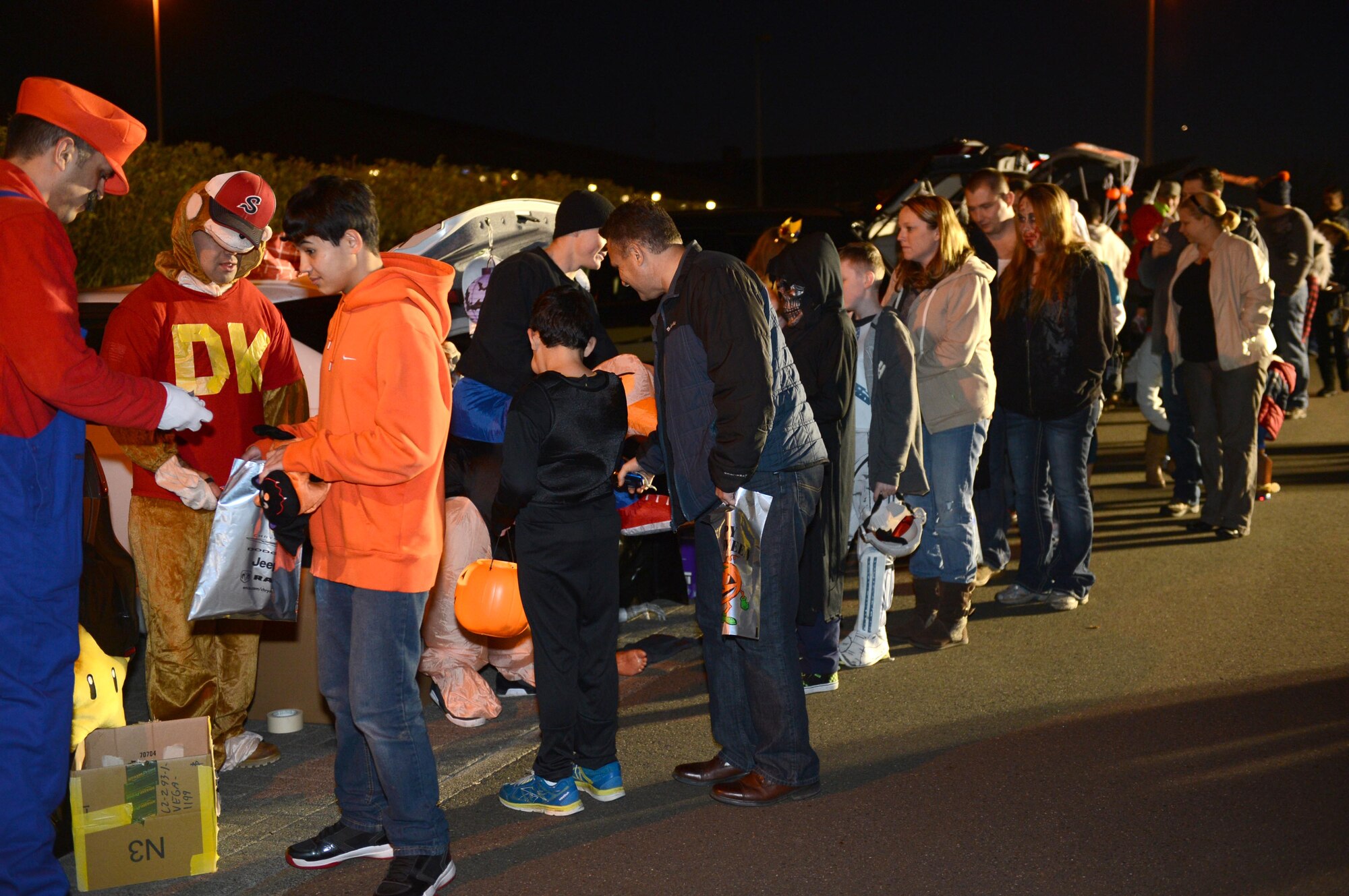 SPANGDAHLEM AIR BASE, Germany – Parents take their children through a parking lot for “trunk or treating” at Club Eifel Oct. 30, 2013. Children were dressed in costumes and walked through the parking lot collecting candy from the community members from their decorated cars’ trunks. (U.S. Air Force photo by Airman 1st Class Kyle Gese/Released)