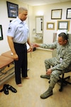 Capt. Felix Islas (right), 359th Medical Group Physical Therapy Flight commander, evaluates Senior Master Sgt. Travis Armstrong, Air Force Personnel Center, July 15 to determine a course of treatment at the Joint Base San Antonio-Randolph medical clinic. (U.S. Air Force photo by Airman 1st Class Alexandria Slade)