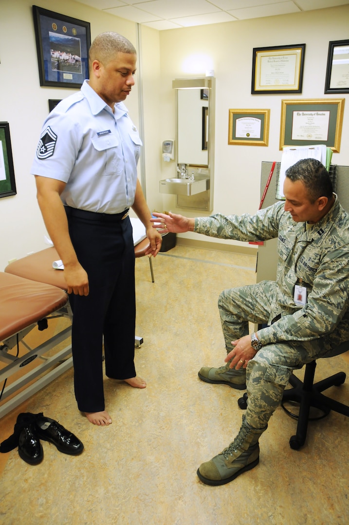 Capt. Felix Islas (right), 359th Medical Group Physical Therapy Flight commander, evaluates Senior Master Sgt. Travis Armstrong, Air Force Personnel Center, July 15 to determine a course of treatment at the Joint Base San Antonio-Randolph medical clinic. (U.S. Air Force photo by Airman 1st Class Alexandria Slade)