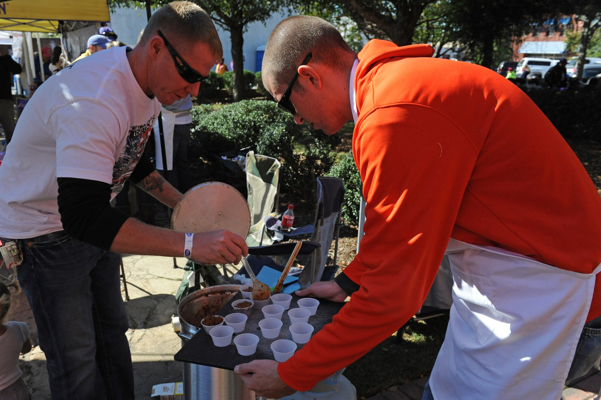 U.S. Air Force Staff Sgt. Justin Baker, 4th Medical Operations Squadron NCO-in charge, and Airman 1st Class Michael Sumner, 4th aircraft Maintenance Squadron assistant dedicated crew chief, fill sample cups with chili during the Really Chili Challenge in Goldsboro, N.C., Oct. 26, 2013. Seymour Johnson Air Force Base’s Group 5/6, a private organization, entered this years contest after finishing second last year. (U.S. Air Force photo by Airman 1st Class Aaron J. Jenne/Released)