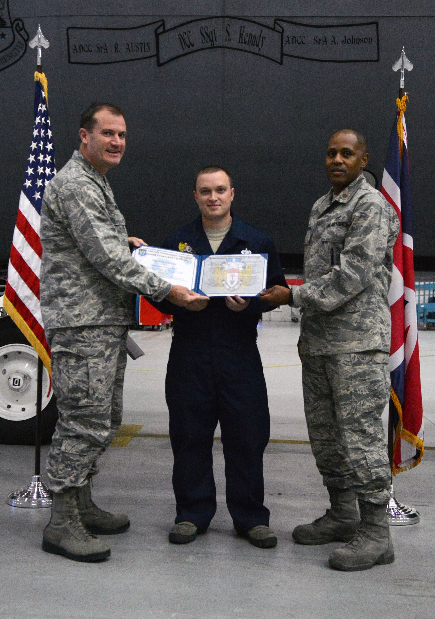 U.S. Air Force Col. Kenneth T. Bibb Jr., left, 100th Air Refueling Wing commander, and U.S. Air Force Maj. Rofelio Grinston, right, 100th Aircraft Maintenance Squadron commander, present a dedicated crew chief award to U.S. Air Force Staff  Sgt. Scott Kenady, center, 100th Aircraft Maintenance Squadron dedicated crew chief from McKinney, Texas, Oct. 30, 2013, on RAF Mildenhall, England. To be selected as a dedicated crew chief, maintainers must have extensive knowledge of their aircraft and embody strong leadership and an internal drive to succeed. Dedicated crew chiefs are honored with their names being painted on their aircraft. (U.S. Air Force photo by Airman 1st Class Kyla Gifford/Released)