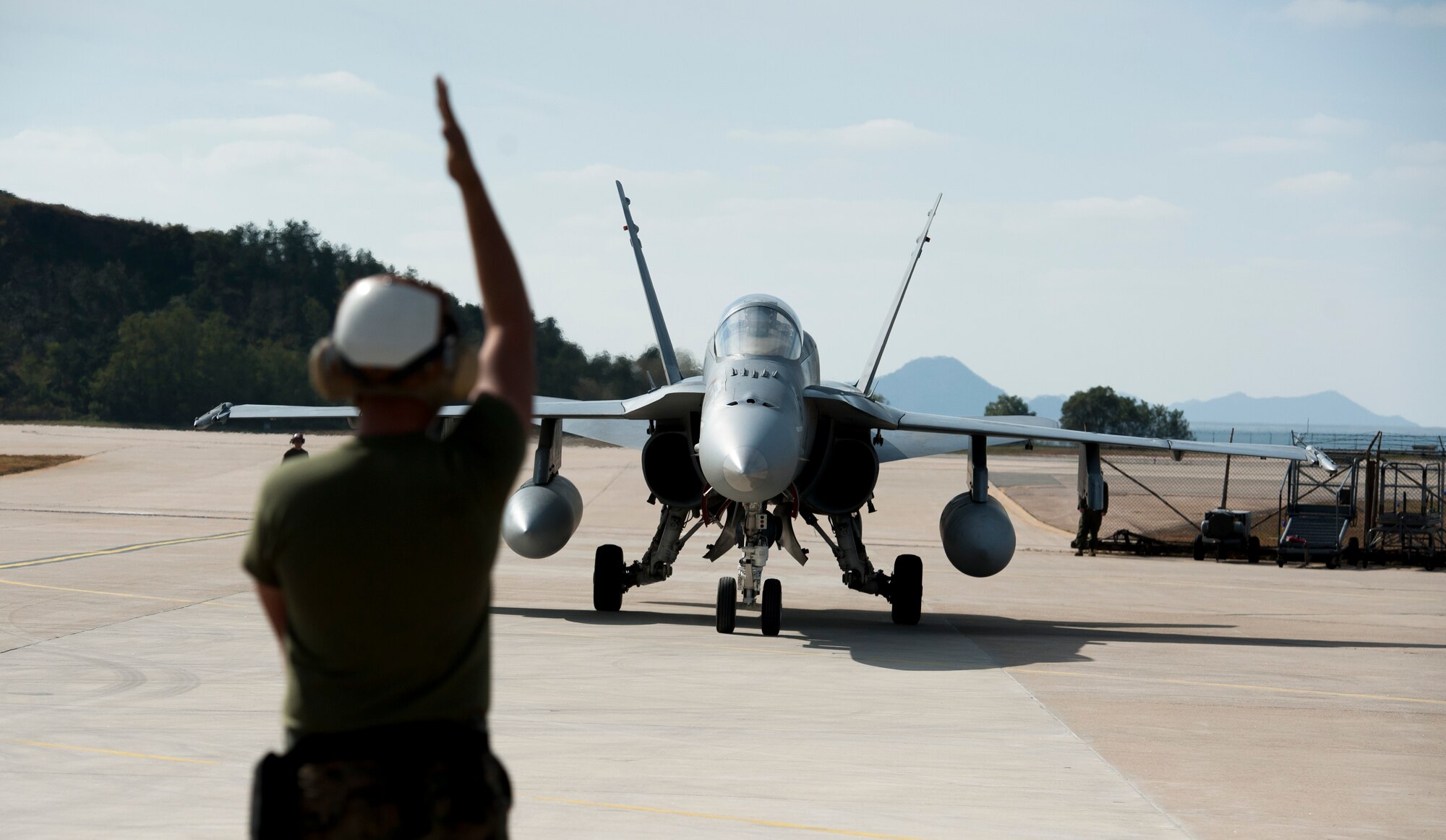 A U.S. Marine corps crew chief directs an F-18 Hornet after a Max Thunder flight at Kunsan Air Base, Republic of Korea, Oct. 30, 2013. Maintainers from the Max Thunder team worked day and night in order to maintain the schedule. This is the 11th Max Thunder exercise, which fosters bilateral aerial training between the Korea Air Power Team to include the U.S. Air Force, Marine Corps and the Republic of Korea air force. (U.S. Air Force photo by Senior Airman Armando A. Schwier-Morales)