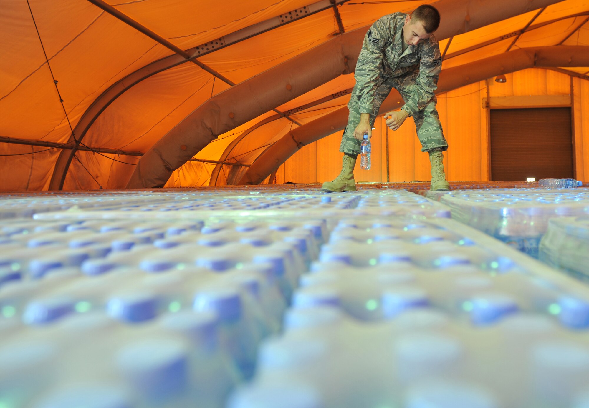 Senior Airman Dustyn White pulls a bottle of water from a new shipment at the 379th Air Expeditionary Wing in Southwest Asia, Oct. 27, 2013. Bottles are pulled from each water shipment for testing prior to being delivered to the base populace. White is the 379th Expeditionary Medical Group Bioenvironmental Engineering environmental quality program manager deployed from Holloman Air Force Base, N.M., and a Porterville, Calif., native. (U.S. Air Force photo/Master Sgt. David Miller)