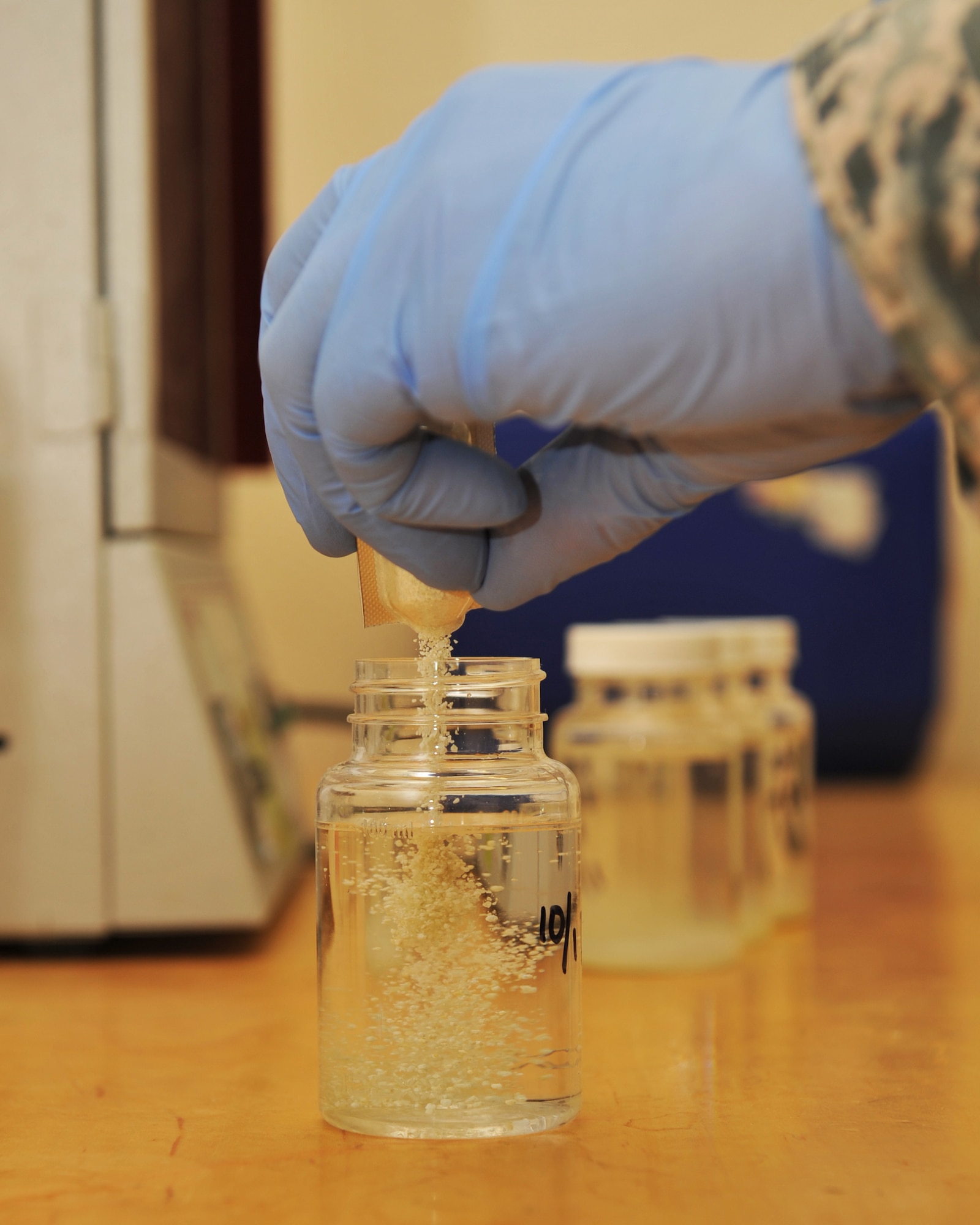 Senior Airman Dustyn White pours Colilert® into a water sample at the 379th Air Expeditionary Wing in Southwest Asia, Oct. 25, 2013. Random bottles of water are tested for bacteriological contaminants prior to being released to the base populace for consumption. White is the 379th Expeditionary Medical Group Bioenvironmental Engineering environmental quality program manager deployed from Holloman Air Force Base, N.M., and a Porterville, Calif., native. (U.S. Air Force photo/Master Sgt. David Miller)