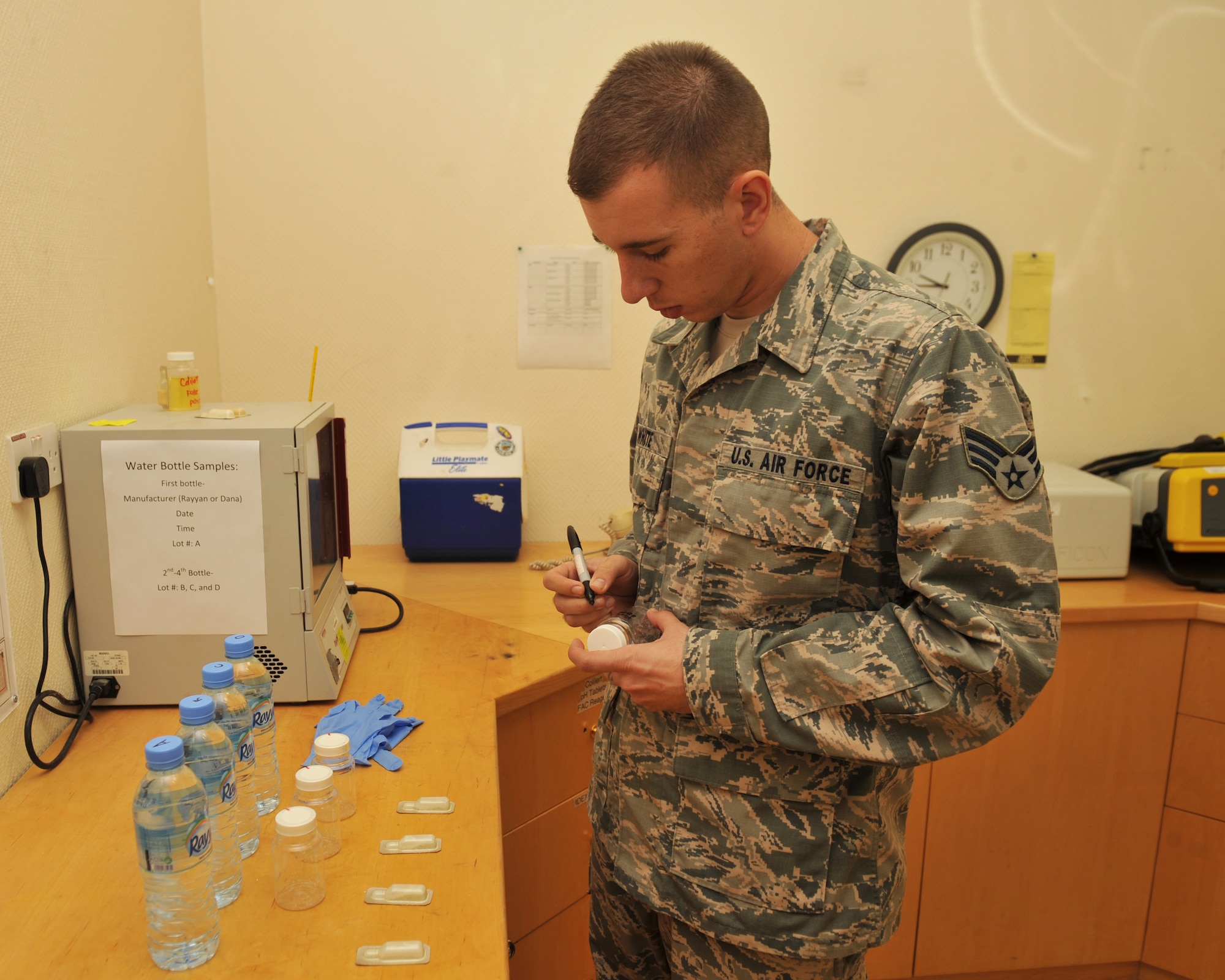 Senior Airman Dustyn White labels testing bottles at the 379th Air Expeditionary Wing in Southwest Asia, Oct. 25, 2013. Random bottles of water are tested for bacteriological contaminants prior to being released to the base populace for consumption. White is the 379th Expeditionary Medical Group Bioenvironmental Engineering environmental quality program manager deployed from Holloman Air Force Base, N.M., and a Porterville, Calif., native. (U.S. Air Force photo/Master Sgt. David Miller)
