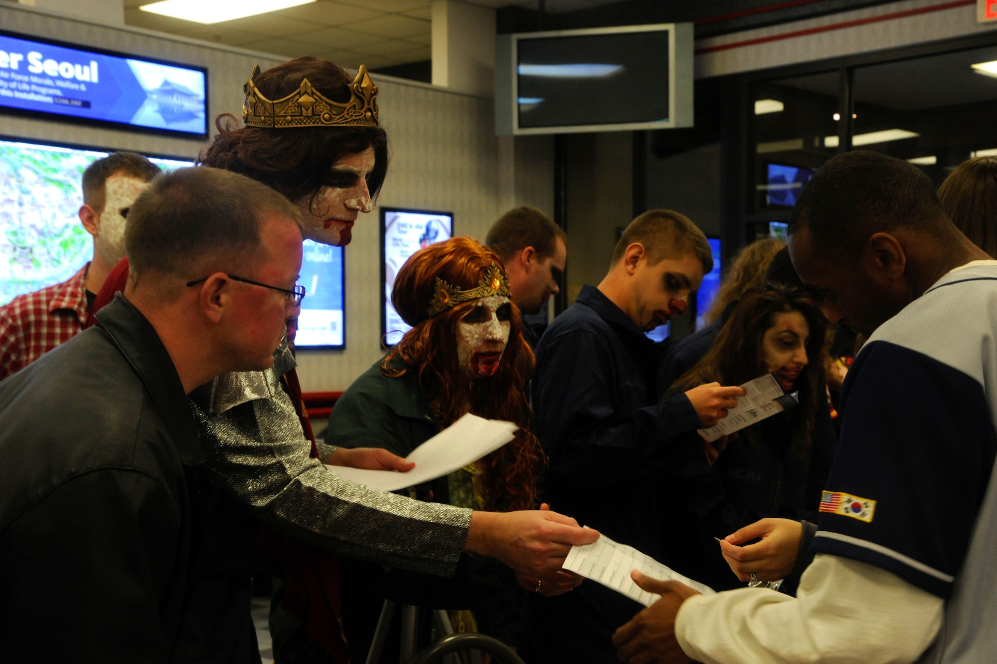 A team reads a trivia question at the Base Exchange at Kunsan Air Base, Republic of Korea, Oct. 26, 2013 as part of the Top 3 sponsored Halloween Scavenger Hunt. To win the hunt, teams were required to travel to a variety of locations throughout base, answer Kunsan and Squadron heritage questions and take photographs.  Each task completed was worth points. (U.S. Air Force photo by Staff Sgt. Jessica Haas/Released)