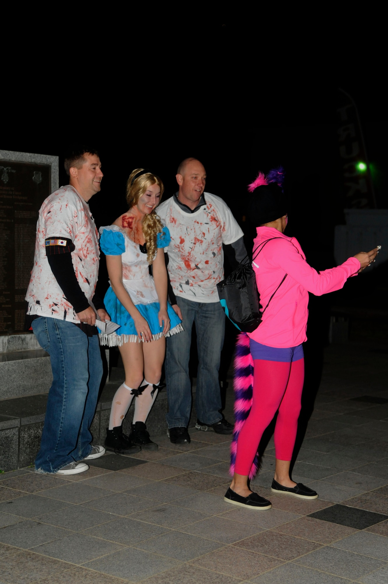 An 8th Civil Engineer Squadron team poses for a picture in front of the Prisoner of War Memorial at Kunsan Air Base, Republic of Korea, Oct. 26, 2013 as part of the Top 3 sponsored Halloween Scavenger Hunt.  To win the hunt, teams were required to travel to a variety of locations throughout base, answer Kunsan and Squadron heritage questions and take photographs.  Each task completed was worth points. (U.S. Air Force photo by Staff Sgt. Jessica Haas/Released)