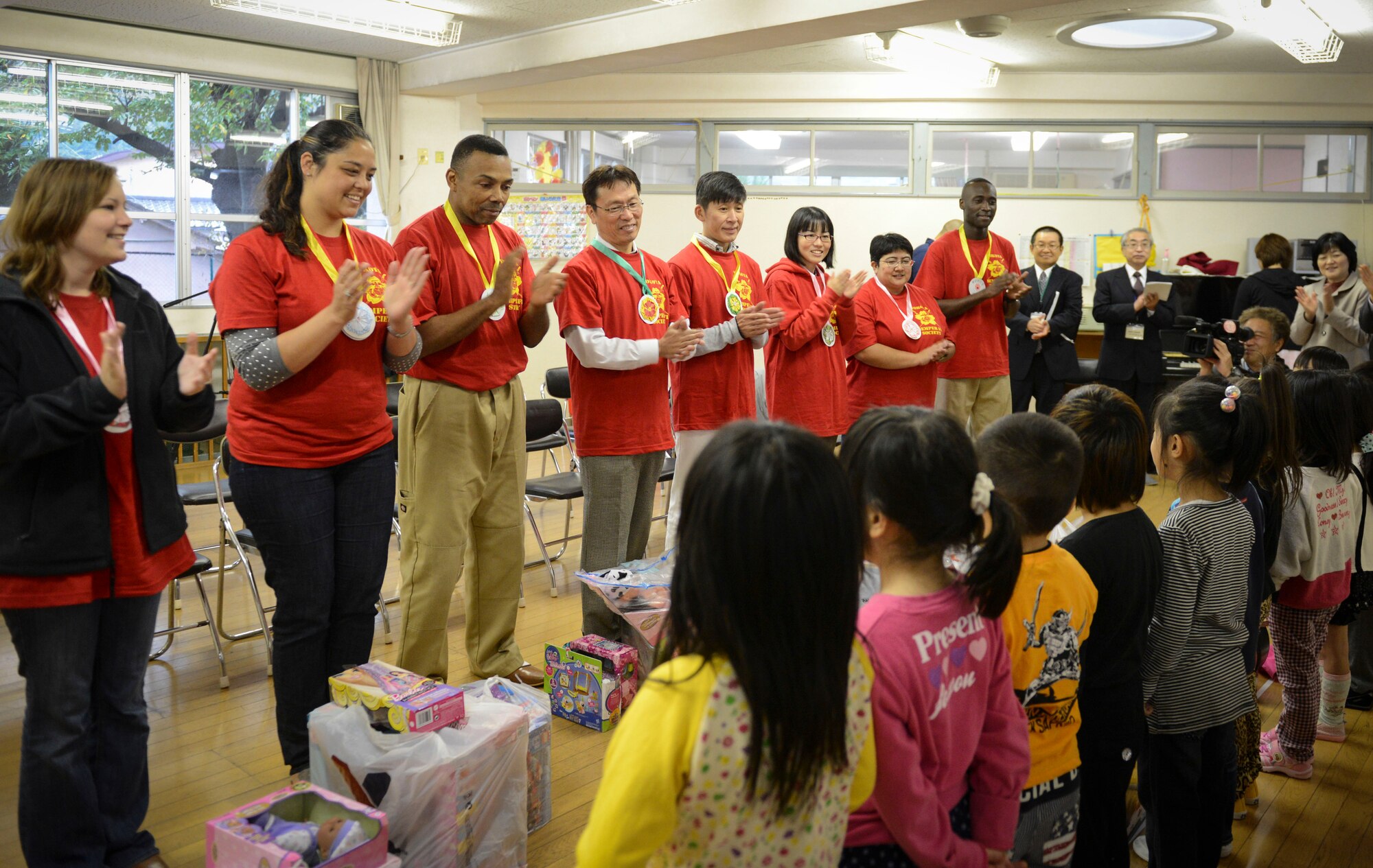 Semper Fi Society members clap as children sing a song at Kaminakajima preschool in Kamaishi-shi, Japan, Oct. 25, 2013.  This is the second time the Semper Fi Society has gone to Kamaishi to deliver toys since 2012. (U.S. Air Force photo by Airman 1st Class Meagan Schutter/Released)