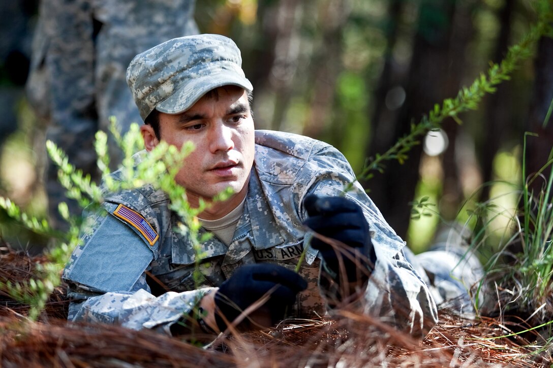 Army 2nd Lt. Noah Russell moves vegetation onto a subsurface site during a leaders course on reconnaissance surveillance on Benning, Ga., Oct. 23, 2013. Russell is assigned to Company C, the 525th Battlefield Surveillance Brigade, 1st Squadron, 38th Cavalry Regiment.