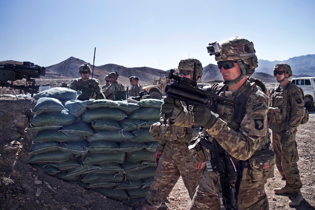 U.S. Army Maj. Kamil Sztalkoper, foreground, fires an M320 grenade launcher at the weapons range on Forward Operating Base Thunder in Afghanistan's Paktia province, Oct. 18, 2013. Sztalkoper, a public affairs officer, is assigned to the 101st Airborne Division's 4th Brigade Combat Team.