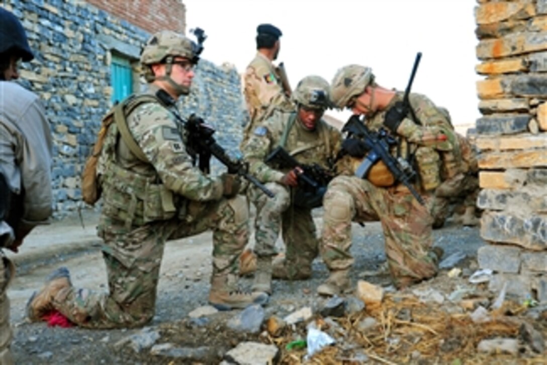 U.S. Army Capt. Lou Cascino, left, pulls security while Staff Sgt. Eric Stephens, center, and 1st Lt. James Kromhout verify their position during a partnered patrol in the village of Madi Khel in the Khowst Province of Afghanistan on Oct. 20, 2013.  The soldiers are conducting a partnered operation with the newly formed Khowst Provincial Response Company.  The operation is being used to validate the training that the Khwost PRC recently received and ensure that illegal weapons were not being stored in historical weapons cache points.  