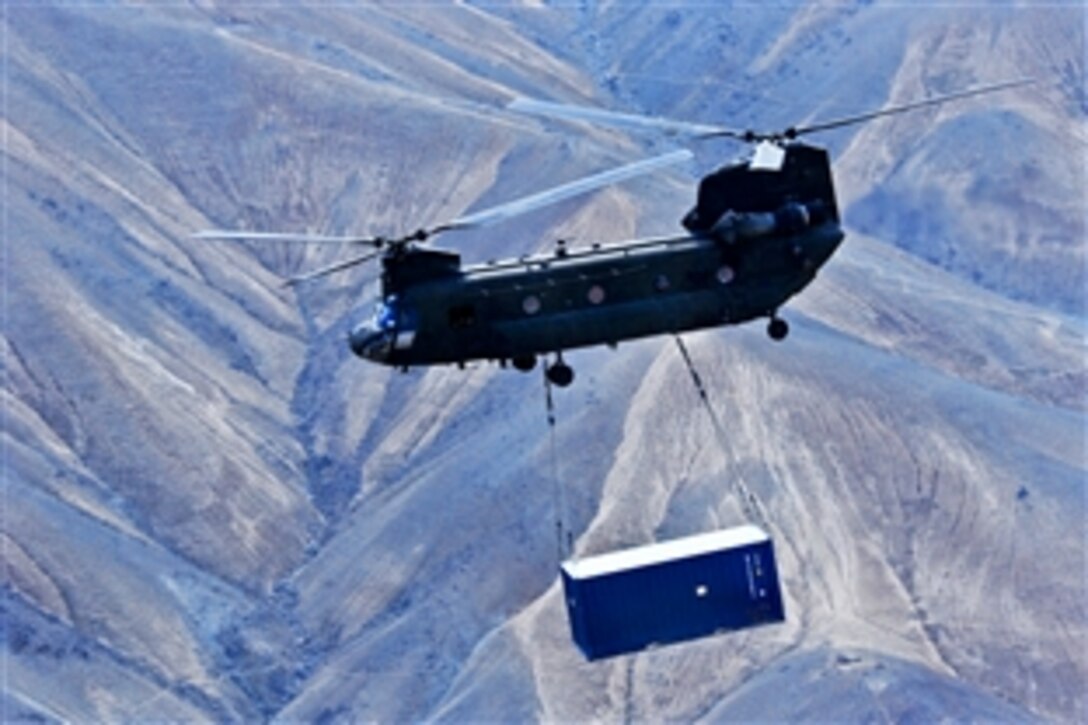 A U.S. Army CH-47 Chinook helicopter carries a shipping container during retrograde operations and base closures in Afghanistan's Wardak province, Oct. 26, 2013.