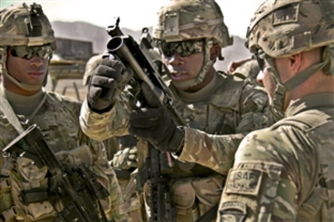 U.S. Army Pfc. Rohan Wright, center, prepares to fire an M203 grenade launcher at the weapons range on Forward Operating Base Thunder in Afghanistan's Paktia province, Oct. 18, 2013. Wright, a cavalry scout, is assigned to the 101st Airborne Division's 4th Brigade Combat Team.