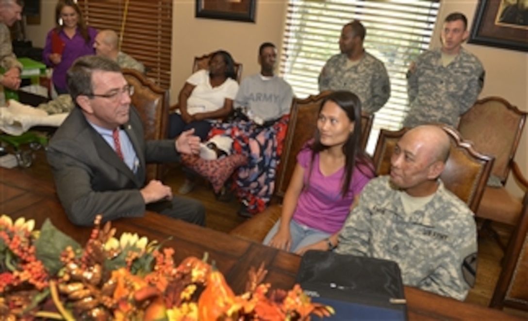 Deputy Secretary of Defense Ashton B. Carter, left, visits with Staff Sgt. Jerry Amis shortly before a ceremony honoring Amis and four other Purple Heart recipients at Brook Army Medical Center and Joint Base San Antonio, Texas, on Oct. 29, 2013.  