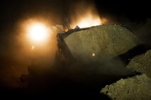 A bulldozer plows through a sand berm during infrastructure improvement operations at Camp Dwyer, Afghanistan, Aug. 13, 2013. A platoon of combat engineers and heavy equipment operators with Combat Logistics Regiment 2, Regional Command (Southwest), worked through the night and endured the constant sting of blowing sand to erect a new guard tower at the base.