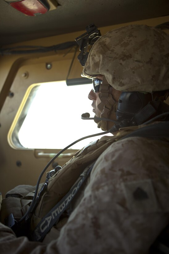 Sgt. Jonathan Vasquez, a New York City police officer and vehicle commander with Combat Logistics Regiment 2, Regional Command (Southwest), looks out the front window of his Mine Resistant, Ambush Protected vehicle during a combat logistics patrol in Helmand province, Afghanistan, Aug. 22, 2013. Vasquez joined the Marine Corps at the age of 17 and became a member of the New York City Police Department.