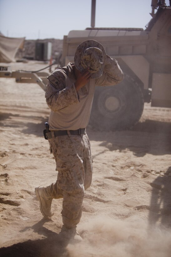 Sgt. Jonathan Vasquez, a New York City police officer and Marine with Combat Logistics Regiment 2, Regional Command (Southwest), ground guides an armored vehicle at a forward operating base in Helmand province, Afghanistan, Aug. 23, 2013. Vasquez joined the Marine Corps at the age of 17 and became a member of the New York City Police Department.