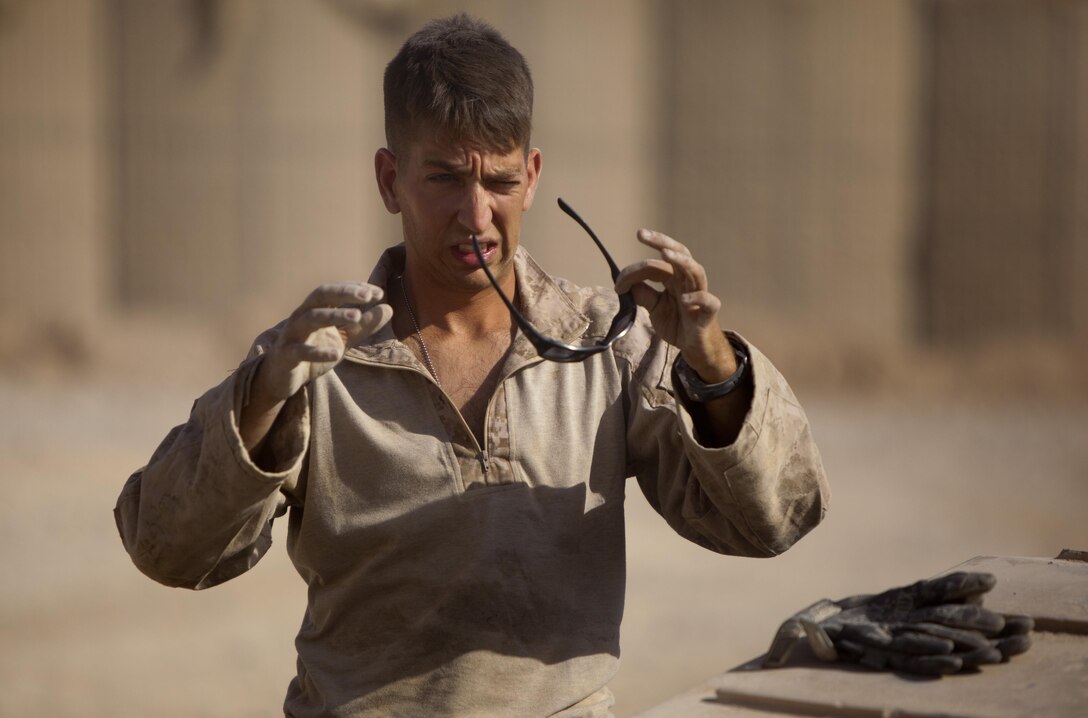 Lance Cpl. Andrew Hodge, a Madison, Conn., native and motor vehicle operator with Combat Logistics Regiment 2, Regional Command (Southwest), grimaces after repairing a break assembly on his vehicle in Helmand province, Afghanistan, Aug. 22, 2013. Hodge's truck took part in a convoy of more than 30 vehicles, which provided simultaneous support to Forward Operating Bases Shir Ghazi and Shukvani.