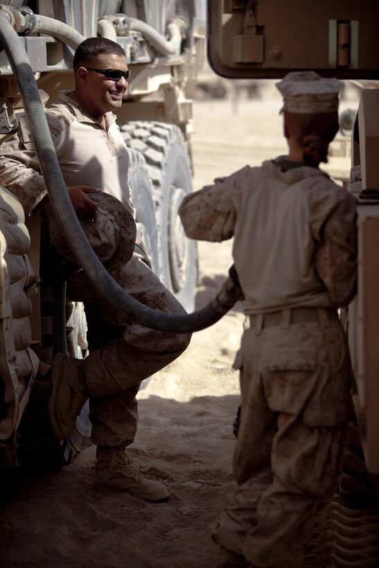 Sgt. Jonathan Vasquez, a New York City police officer and Marine with Combat Logistics Regiment 2, Regional Command (Southwest), jokes with a fellow Marine at a forward operating base in Helmand province, Afghanistan, Aug. 23, 2013. Vasquez joined the Marine Corps at the age of 17 and became a member of the New York City Police Department.