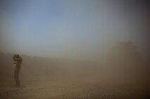A flash sand storm engulfs a Marine with Combat Logistics Regiment 2, Regional Command (Southwest), at the site of infrastructure improvement operations at Camp Dwyer, Afghanistan, Aug. 12, 2013. Sandstorms are common in the area and can appear with little warning.