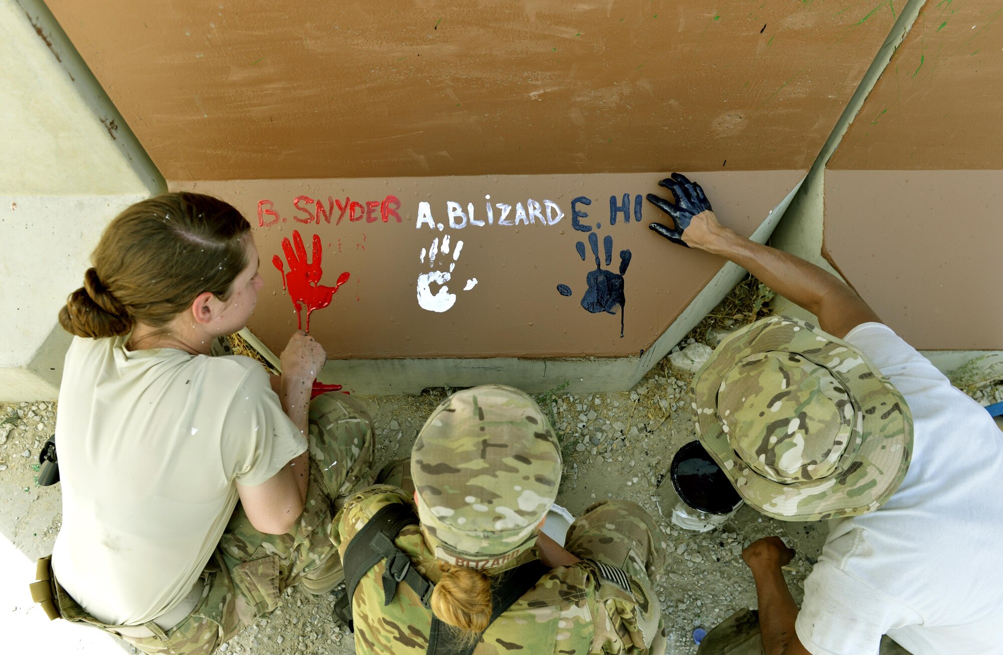 Senior Airman Brittney Snyder, Senior Airman Alyona Blizard and Airman 1st Class Eli Hixson painted their interpretation of unity, respect, trust, strength and the will to protect on a wall leaving a visual legacy for those who follow in their footsteps Aug. 30, 2013, at Camp Cunningham. Snyder is with 455th Air Expeditionary Wing personnel, Blizard is a 455th Expeditionary Communications Squadron communications focal point technician and Hixson is a 455th Expeditionary Aerial Port Squadron air transportation passenger service agent. (U.S. Air Force photo/Staff Sgt. Stephenie Wade)