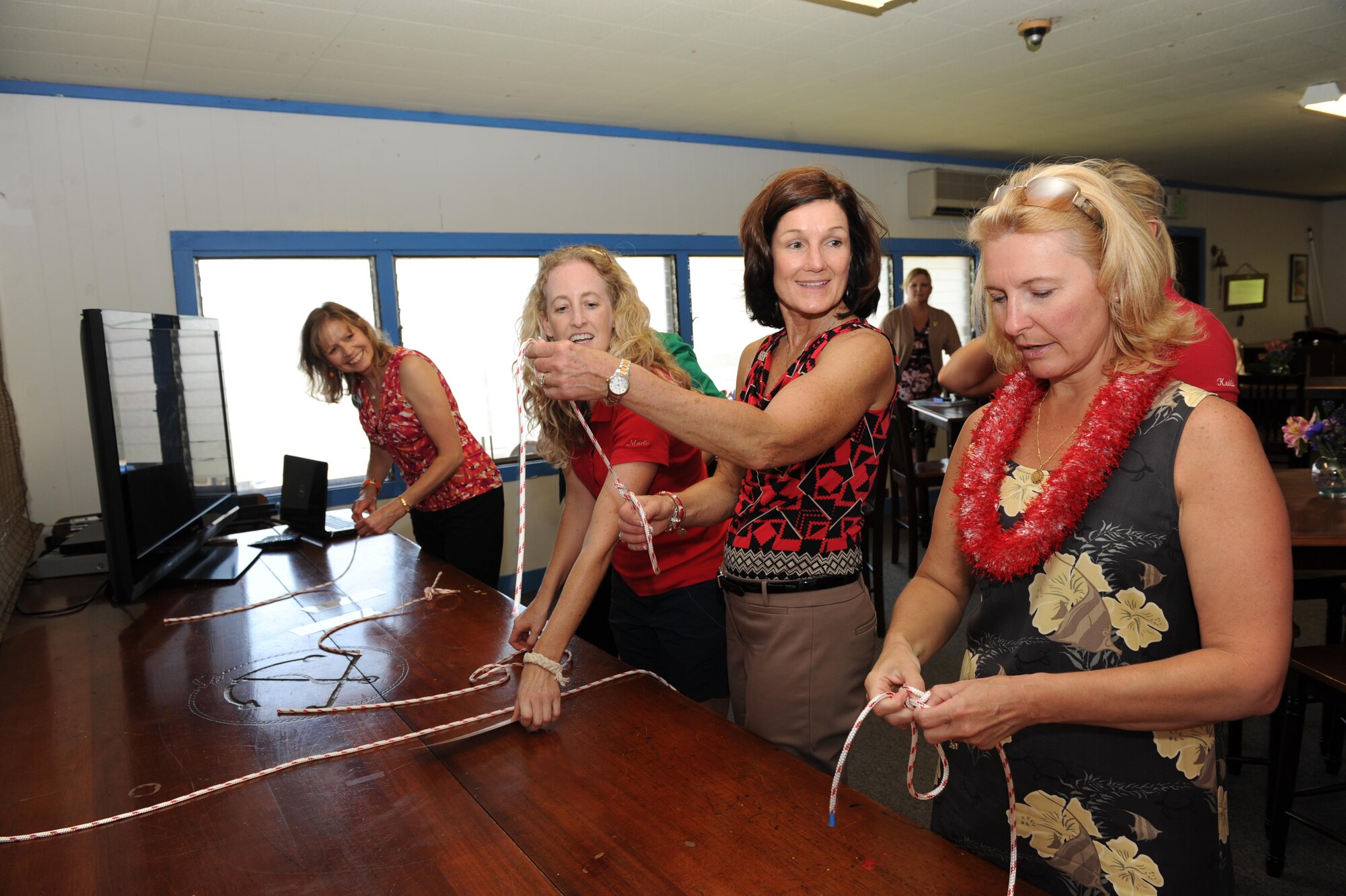 Athena Cody, right, wife of Chief Master Sgt. of the Air Force James A. Cody, and Betty Welsh, wife of Air Force Chief of Staff Gen. Mark A. Welsh III, Marlo Nikkila, Wet Hens treasurer, and Gillian Carlisle, wife of Gen. Hawk Carlisle, commander of Pacific Air Forces, practice tying knots with the spouse's sailing club, 'Wet Hens', at the Outdoor Recreation Center on Joint Base Pearl Harbor-Hickam, Hawaii, Aug. 19, 2013. The visit to Hawaii is part of Gen. Welsh and Chief Cody’s first visit to the Pacific theater and includes stops in Alaska, Japan and the Republic of Korea. Mrs. Welsh and Mrs. Cody met with family members and spouses to discuss opportunities and challenges regarding family care in the Pacific region. (U.S. Air Force photo/Master Sgt. Matthew McGovern)