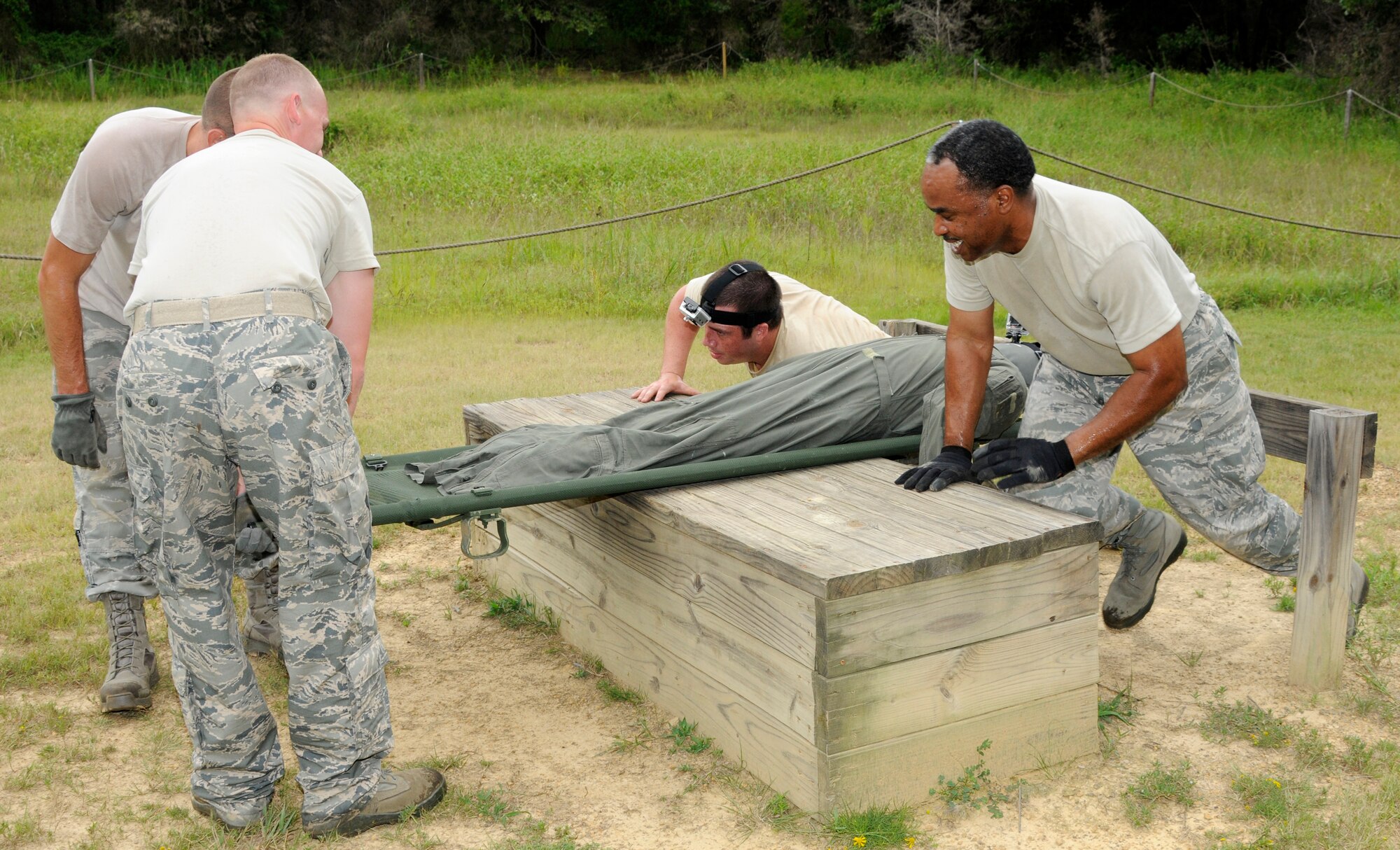 Members of the 188th Security Forces Squadron negotiate the Fort Chaffee Maneuver Training Center obstacle course, Aug. 3, 2013. Teams of four Airmen safely carried a stretcher through the course as part of a team-building exercise. (U.S. Air National Guard photo by Senior Airman Hannah Landeros/188th Fighter Wing Public Affairs)