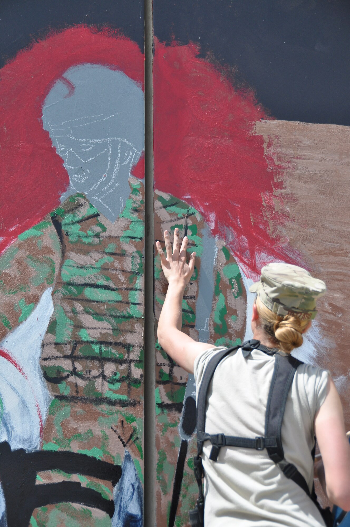 Senior Airman Alyona Blizard, 455th Expeditionary Communications Squadron communications focal point technician, paints a mural depicting the bonds, unity, respect, trust, strength and the will to protect on the walls on Bagram Airfield, Afghanistan, Aug. 30, 2013. Blizard is deployed from Joint Base Langley-Eustis AFB, Va. She is a three-year Air Force veteran who hails from Beckley, W.Va. (U.S. Air Force photo/Tech. Sgt. Rob Hazelett)