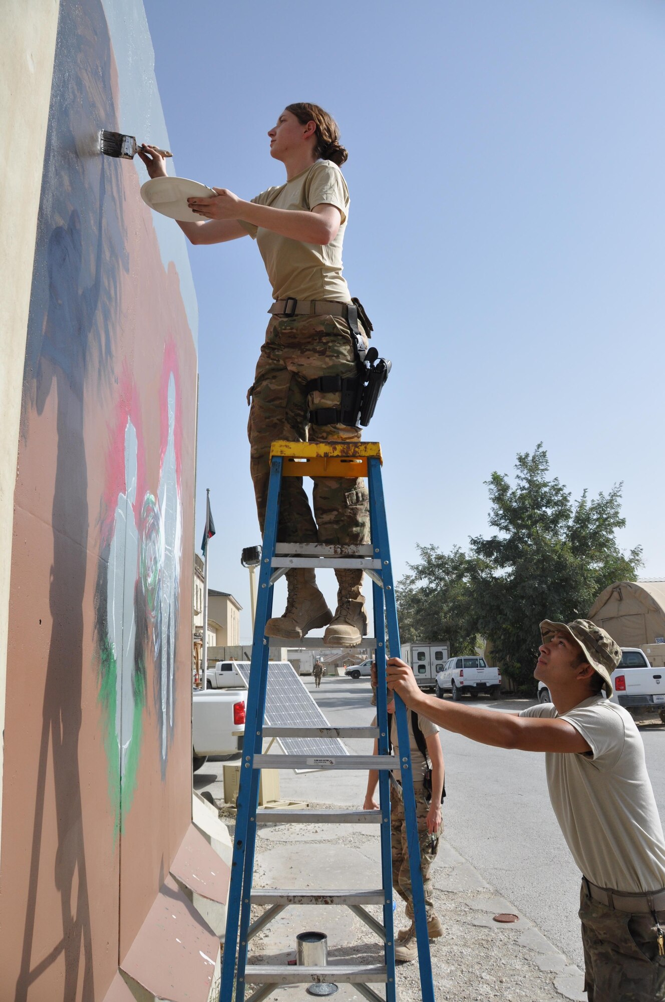 Senior Airman Brittney Snyder, 455th Air Expeditionary Wing personnel support, and Airman 1st Class Eli Hixson, 455th Expeditionary Aerial Port Squadron air transportation passenger service agent, painted their interpretation of unity, respect, trust, strength and the will to protect on a wall leaving a visual legacy for those who follow in their footsteps to see here on Camp Cunningham Aug. 30, 2013. (U.S. Air Force photo/Tech. Sgt. Rob Hazelett)