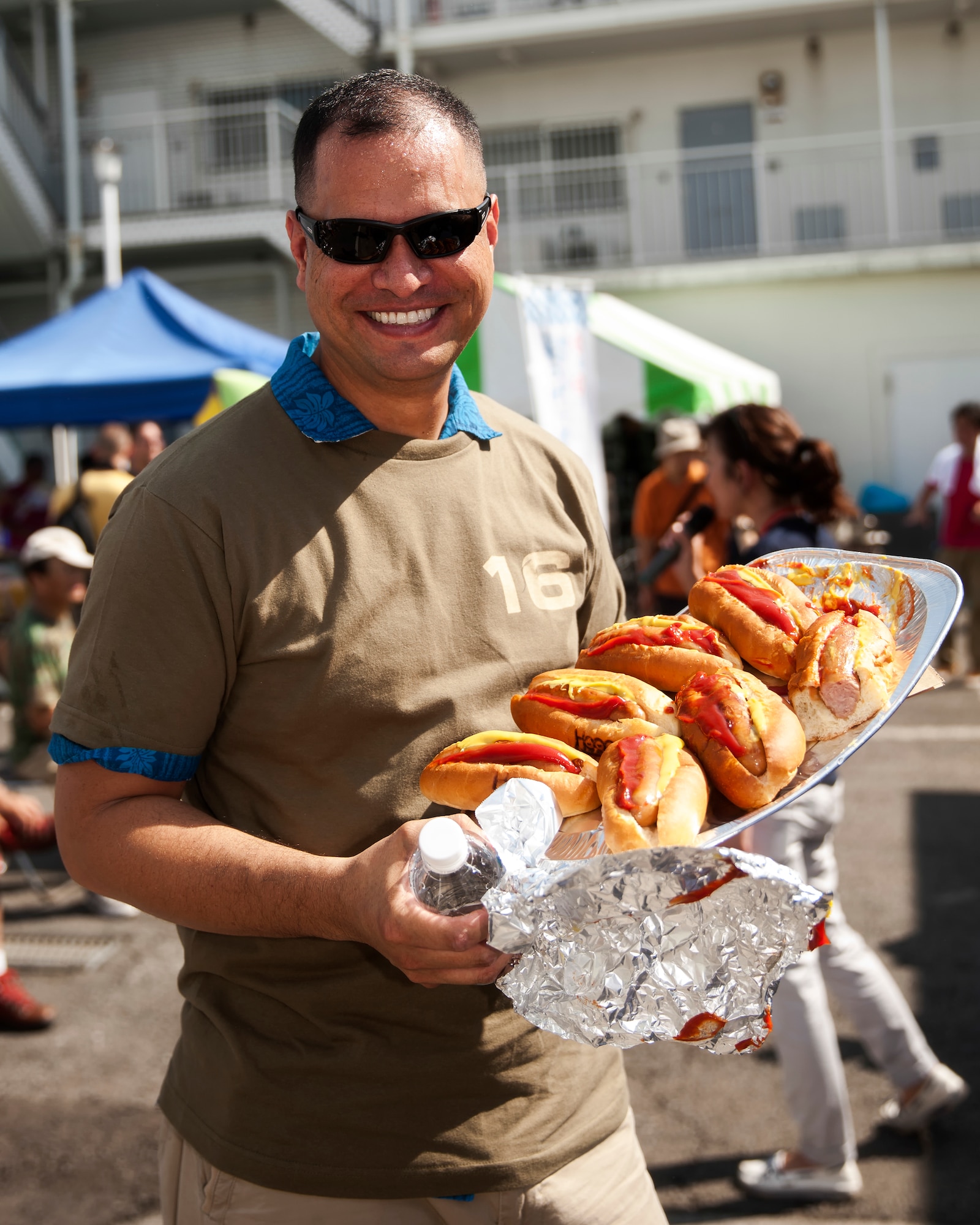 U.S. Air Force Master Sgt. Brandon Kirkham, 374th Maintenance Squadron, poses with leftover hot dogs after the hot dog eating competition during the 25th annual Fussa City International Fair, Aug. 31, 2013. Kirkham ate three and a half hot dogs during a five minutes long competition. (U.S. Air Force photo by Osakabe Yasuo/Released)