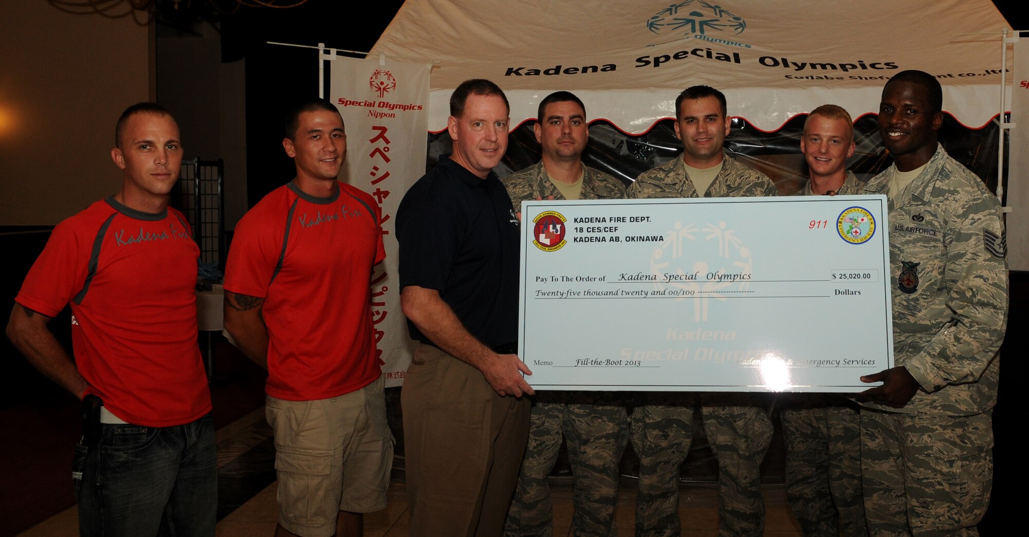 U.S. Air Force Brig. Gen. James Hecker, 18th Wing commander, receives a check from members of the 18th Civil Engineering Squadron’s fire department at the Kadena Air Base Officers’ Club, Aug. 29, 2013. This money was raised for Kadena’s Special Olympics though the Fill the Boot program the fireman recently held. (U.S. Air Force photo by Staff Sgt. Laszlo Babocsi)