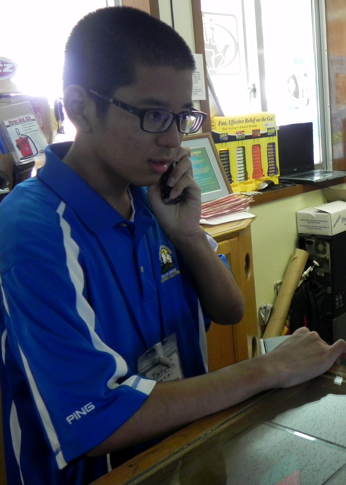 Yusuke Okuma, Kadena Language Institute student intern, answers a phone call at the Kadena Marina on Okinawa, Japan, Aug. 28, 2013. Okuma worked front desk, answered phone calls and checked reservations as well as priced merchandise and spoke with customers during his internship at the Kadena Marina. (U.S. Air Force photo by Yuka Kinjo)