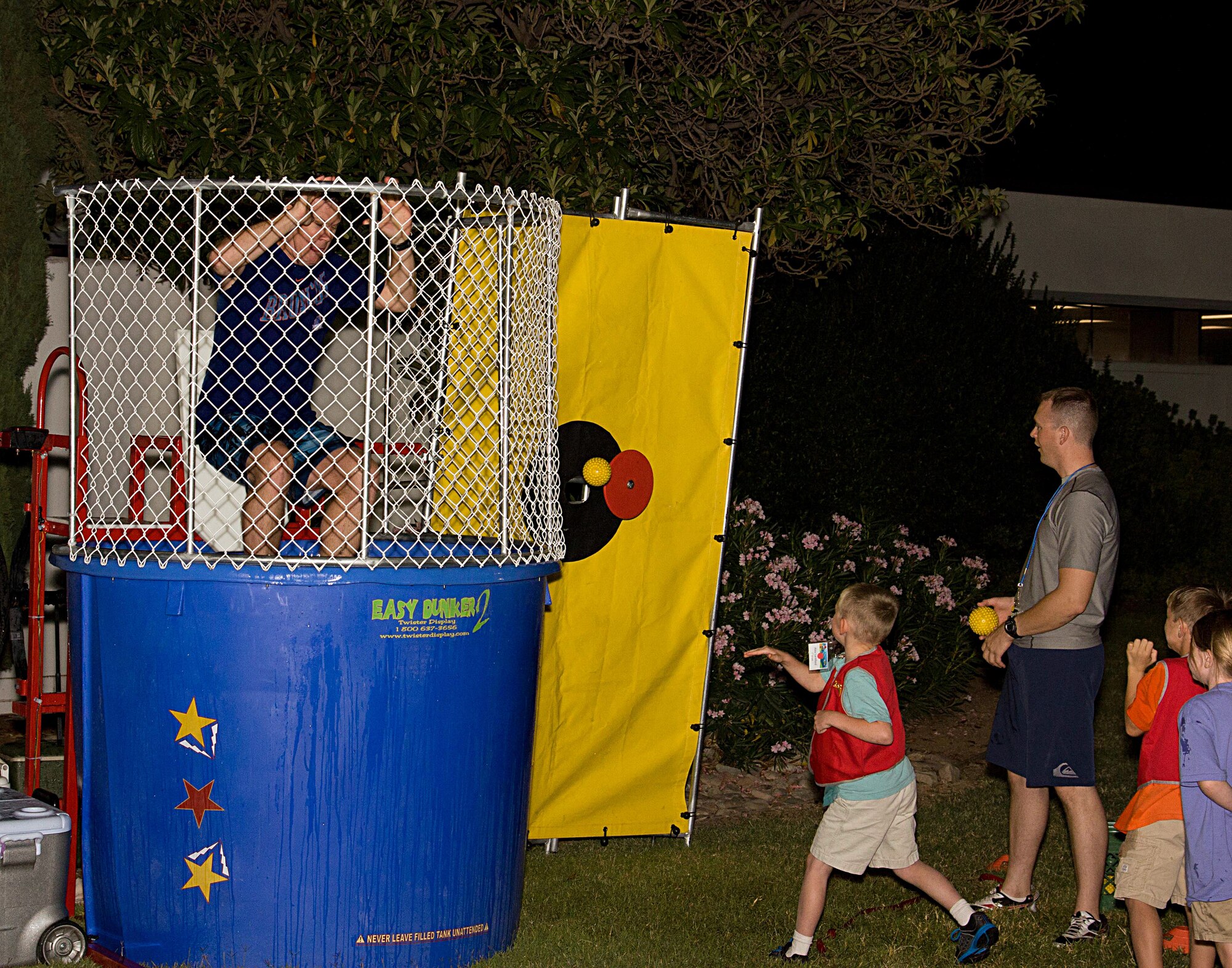 U.S. Air Force Capt. (Chaplain) John Boyer, 355th Fighter Wing, sits in a dunking booth at Davis-Monthan Air Force Base, Ariz., Sept. 26, 2012. The booth was part of an event for the D-M Awana organization, a faith-based initiative to give children and youths a place to have fun while learning about the Bible. (Courtesy photo/Released)