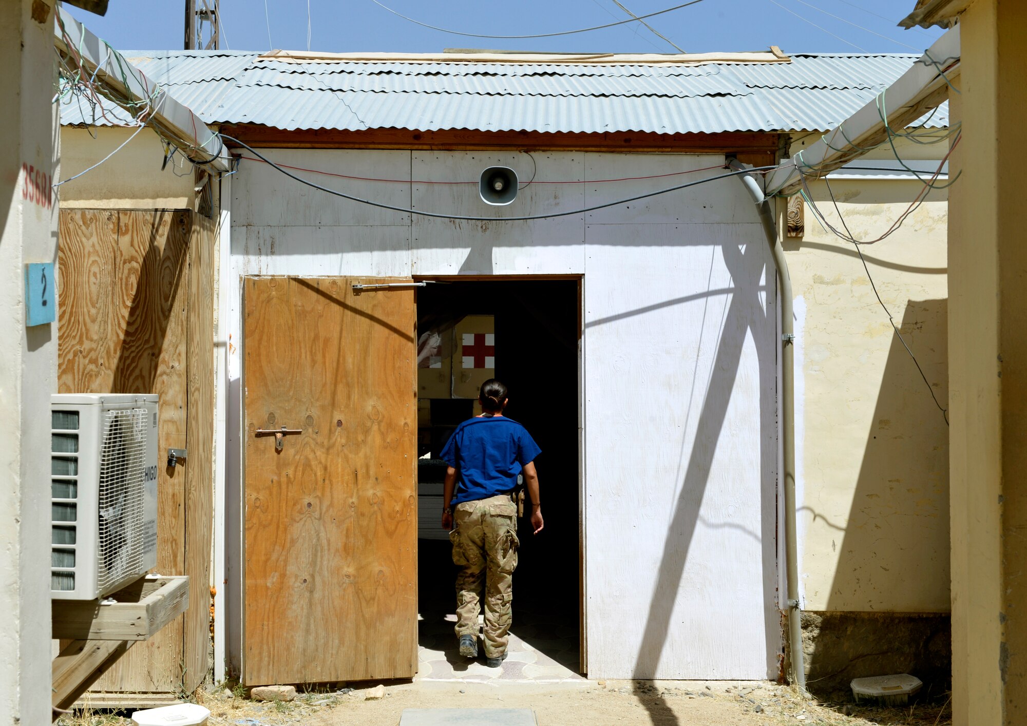 Staff Sgt. Gabriel Diaz, Forward Surgical Team Emergency Room technician, rushes to work from her dorms to prepare for an incoming Afghan patient on Forward Operating Base Ghazni, August 25, 2013. She is in charge of preparing and treating patients in the ER. Diaz is deployed from Travis Air Force Base, Calif. (U.S. Air Force photo/ Staff Sgt. Stephenie Wade)