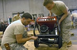 New York Army National Guard Spc. Christopher Miltner and Spc. David De La Mater prep a generator to be used at polling sites in areas affected by Hurricane Sandy.
