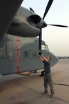 Sgt. Clint Walker, flight engineer with A Company, 641st Aviation Regiment, rotates the propeller of a C-23 Sherpa and checks it for damage and problems as part of his preflight checks and inspections.