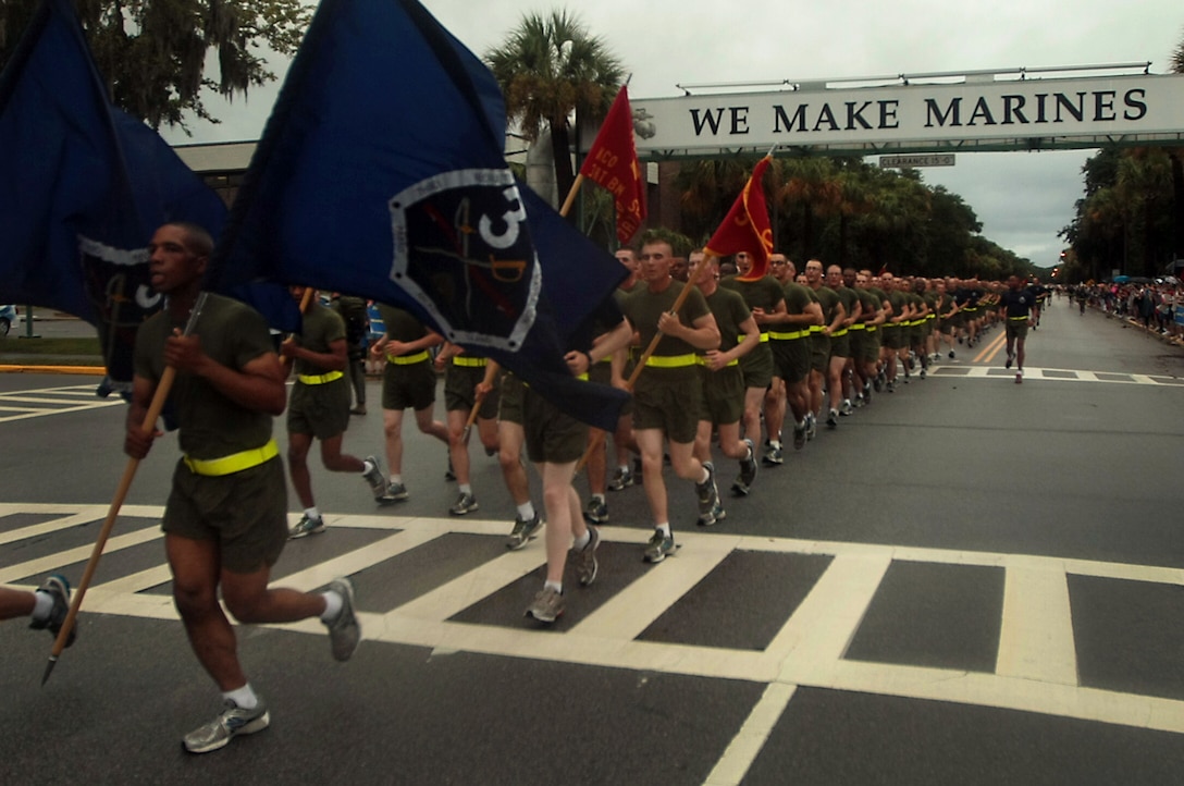 New Marines of Kilo Company, 3rd Recruit Training Battalion, run under the “We Make Marines” sign during a traditional motivational run through the streets of Parris Island, S.C., on Aug 15, 2013. The run took place before the new Marines had a few hours to reunite with their friends and families for the first time in more than 12 weeks. Kilo Company is scheduled to graduate Aug. 16, 2013. Parris Island has been the site of Marine Corps recruit training since Nov. 1, 1915. Today, approximately 20,000 recruits come to Parris Island annually for the chance to become United States Marines by enduring 13 weeks of rigorous, transformative training. Parris Island is home to entry-level enlisted training for 50 percent of males and 100 percent for females in the Marine Corps. (Photo by Cpl. Caitlin Brink)