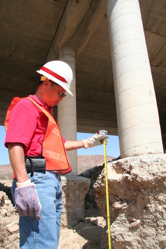 Tony Wong, a structural engineer, inspects Bridge 13 on Fort Irwin.  The raging waters and debris flow from the monsoonal rainfall eroded the soil and concrete around the bridges’ support columns. The bridge has been closed pending further analysis of the damage. 