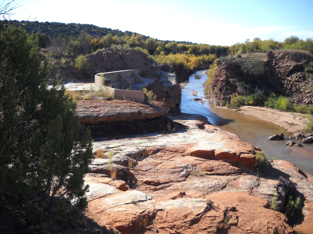 Destroyed West Puerto de Luna diversion dam on Agua Negra Creek. Formerly, an earthen and masonry wall existed where the creek now flows, and water was diverted towards the left of the image through a headgate (hidden by the juniper) into the WPdL Ditch, with excess water flowing down the spillway (foreground). The dam was destroyed by flooding in 2006, but has since been rebuilt by the Corps of Engineers.