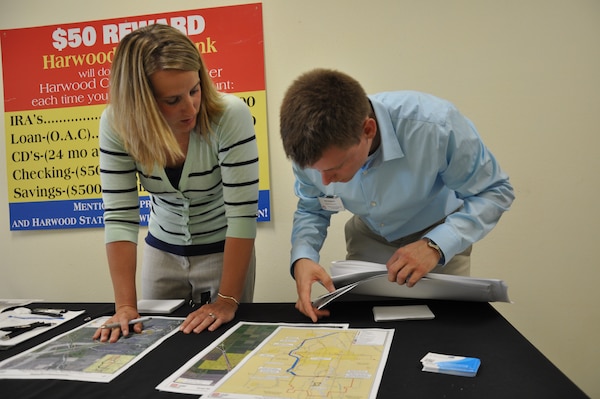 FARGO, N.D. -- Katie Opsahl, planning, left; and Bob Edstrom, project management, prepare for a public meeting about the Fargo, N.D./ Moorhead, Minn., Metropolitan Area Flood Risk Management Project in Fargo June 26.