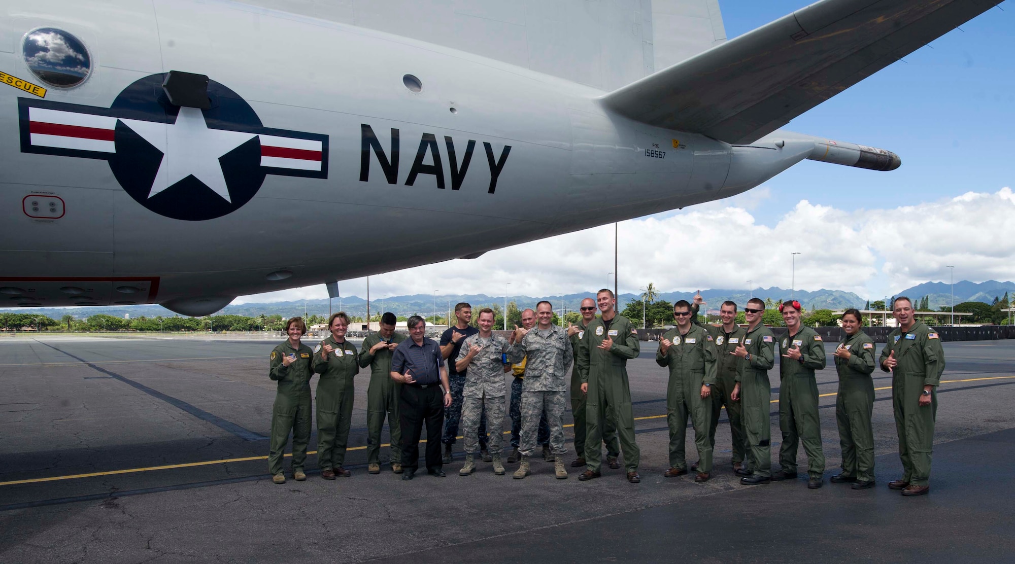 Lt. Col. David Milner, 15th Wing Operations Support Squadron commander, (left) Col. Johnny Roscoe, 15th Wing commander, (center) and Navy Capt. Lance Scott, commander, Patrol and Reconnaissance Wing Two, pose for a group photo and toss up Hawaiian shakas with a P-3 Orion aircrew after the aircraft arrived on Joint Base Pearl Harbor-Hickam, Hawaii, Aug. 23, 2013. The P-3 was the first of 16 fixed-wing aircraft to relocate from Navy Patrol Squadron NINE at Marine Corps Base Hawaii because of runway renovations. More than 175 of the unit’s personnel will also relocate to provide aircraft maintenance and support. (U.S. Air Force photo/Staff Sgt. Terri Paden)