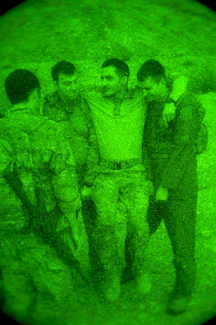 Capt. Kyle Wamser (left) and Capt. Alex Sira (right), 66th Rescue Squadron HH-60 Pave Hawk pilots, assist Capt. Bret Cove, 66th RQS HH-60 Pave Hawk pilot, during a survival, evasion, resistance, escape familiarization training Aug. 23, 2013, at Area 2, Nellis Air Force Base, Nev. During a simulated aircraft accident, Cove “lost” both of his legs, and his fellow Airmen carried him away from hostile contact. (U.S. Air Force photo by Senior Airman Brett Clashman)