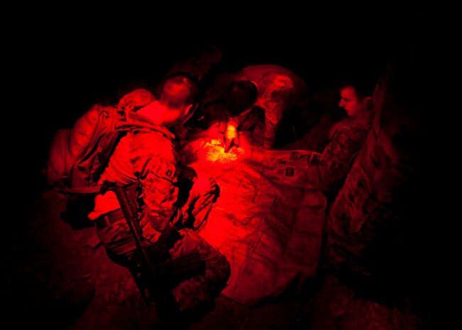 Capt. Bret Cove (left) and Capt. Alex Sira (right), 66th Rescue Squadron HH-60 Pave Hawk pilots, establish coordinates on a map while Staff Sgt. Craig Wheeler, 66th Rescue Squadron special missions aviator, observes during a survival, evasion, resistance, escape familiarization training Aug. 23, 2013, at Area 2, Nellis Air Force Base, Nev. SERE specialists teach students how to adapt to all environments and their associated weather conditions. (U.S. Air Force photo by Senior Airman Brett Clashman)