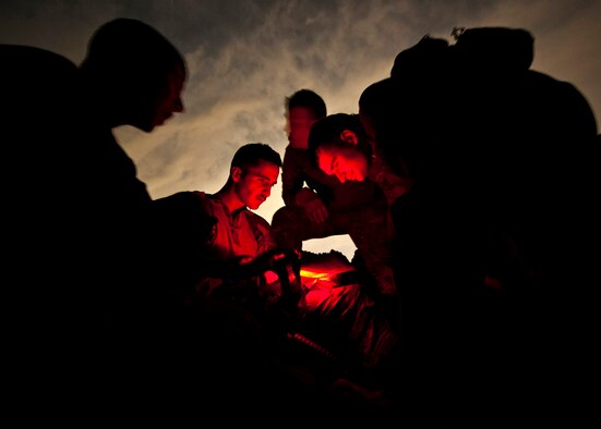 Capt. Bret Cove (left) and Capt. Kyle Wamser (right), 66th Rescue Squadron HH-60 Pave Hawk pilots, establish coordinates on a map during a survival, evasion, resistance, escape familiarization training Aug. 23, 2013, at Area 2, Nellis Air Force Base, Nev. The training educates Airmen who have been determined to be at a high risk of isolation the methods used to survive in the arctic, desert, open ocean, jungle and mountain regions. (U.S. Air Force photo by Senior Airman Brett Clashman)
