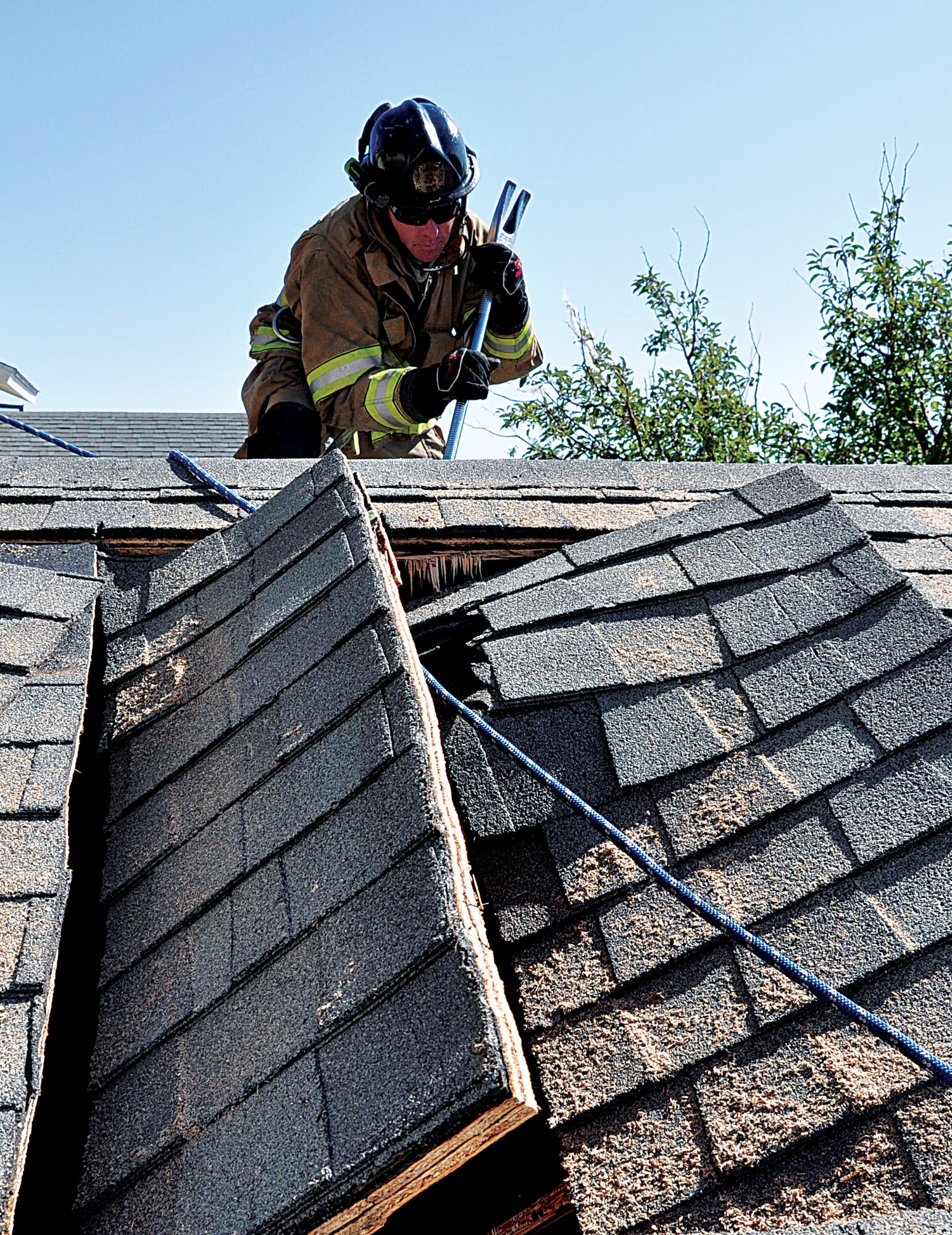 130829-F-DY381-118
Jesse Johnson, 90th Civil Engineer Fire Department firefighter, uses a halligan — a multipurpose tool — to demonstrate how to mark a roof for a vertical ventilation Aug. 29, 2013 on a soon-to-be demolished base house, during the week-long joint training exercise with the Cheyenne, Wyo., fire department. In the foreground is an example of what a completed vertical ventilation looks like. (U.S. Air Force photo by Senior Airman Mike Tryon)
