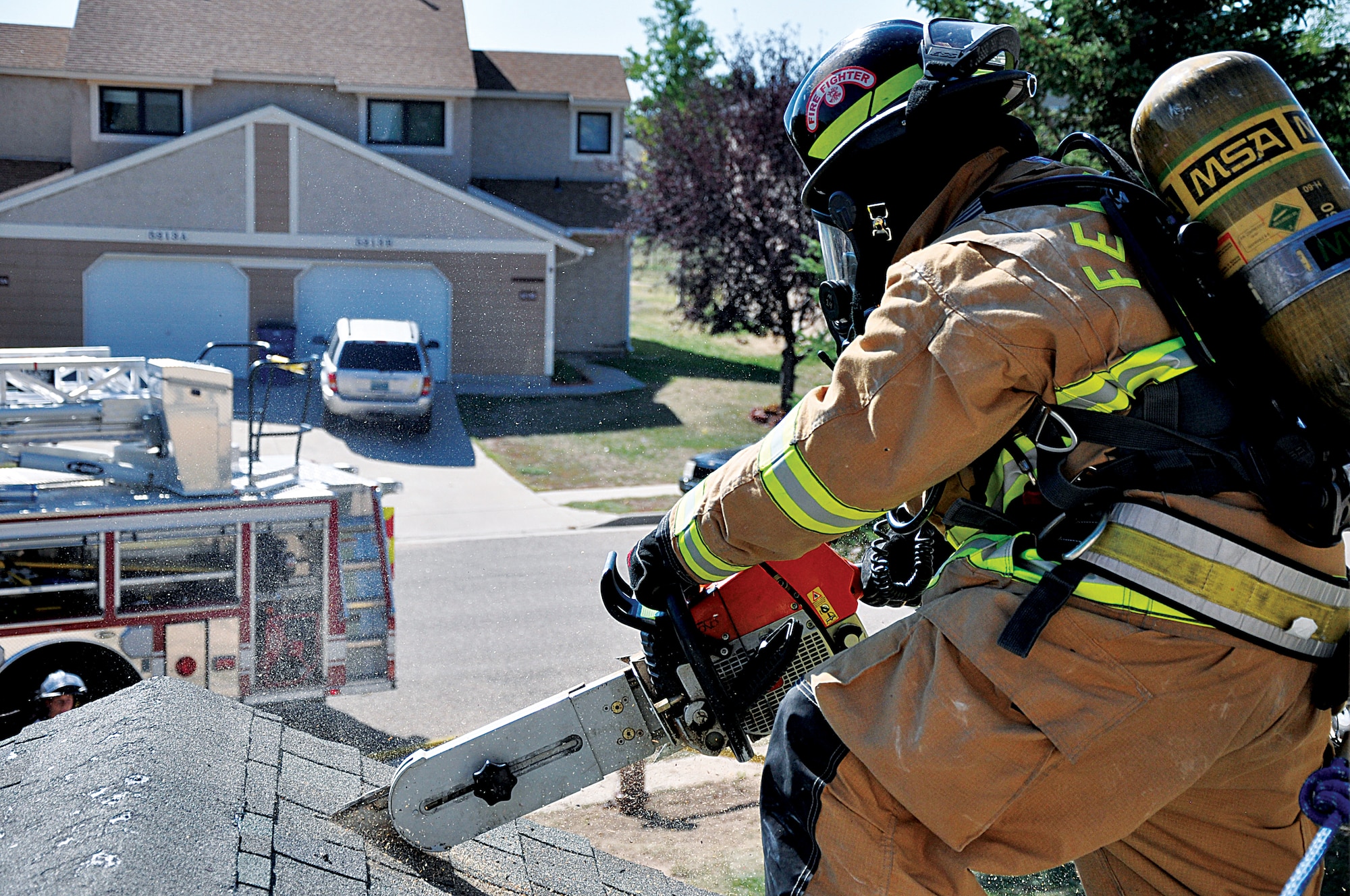 130829-F-DY381-077
Airman 1st Class Nicholas Meno, 90th Civil Engineer Squadron Fire Department firefighter, cuts through the roof a base house Aug. 29, 2013, during a week-long joint training exercise with the Cheyenne, Wyo., fire department. Cutting through the roof is the final step in a vertical ventilation procedure. Vertical ventilation consists of locating and marking the studs of a roof and then cutting through the roof along the marks. (U.S. Air Force photo by Senior Airman Mike Tryon)
