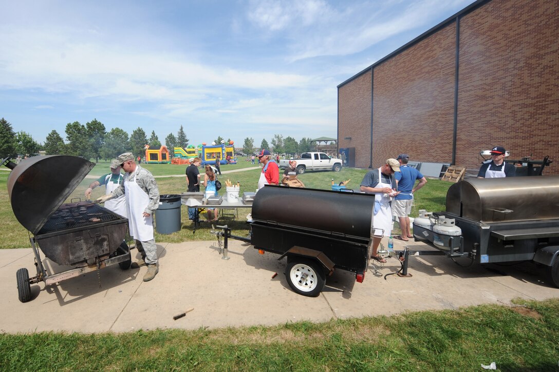 Volunteers cook burgers and hot dogs during the base picnic at the Bellamy Fitness Center on Ellsworth Air Force Base, S.D., Aug. 23, 2013. During the picnic, 1,600 meals were served along with snow cones, cotton candy, and popcorn. (U.S. Air Force photo by Airman 1st Class Rebecca Imwalle/Released)