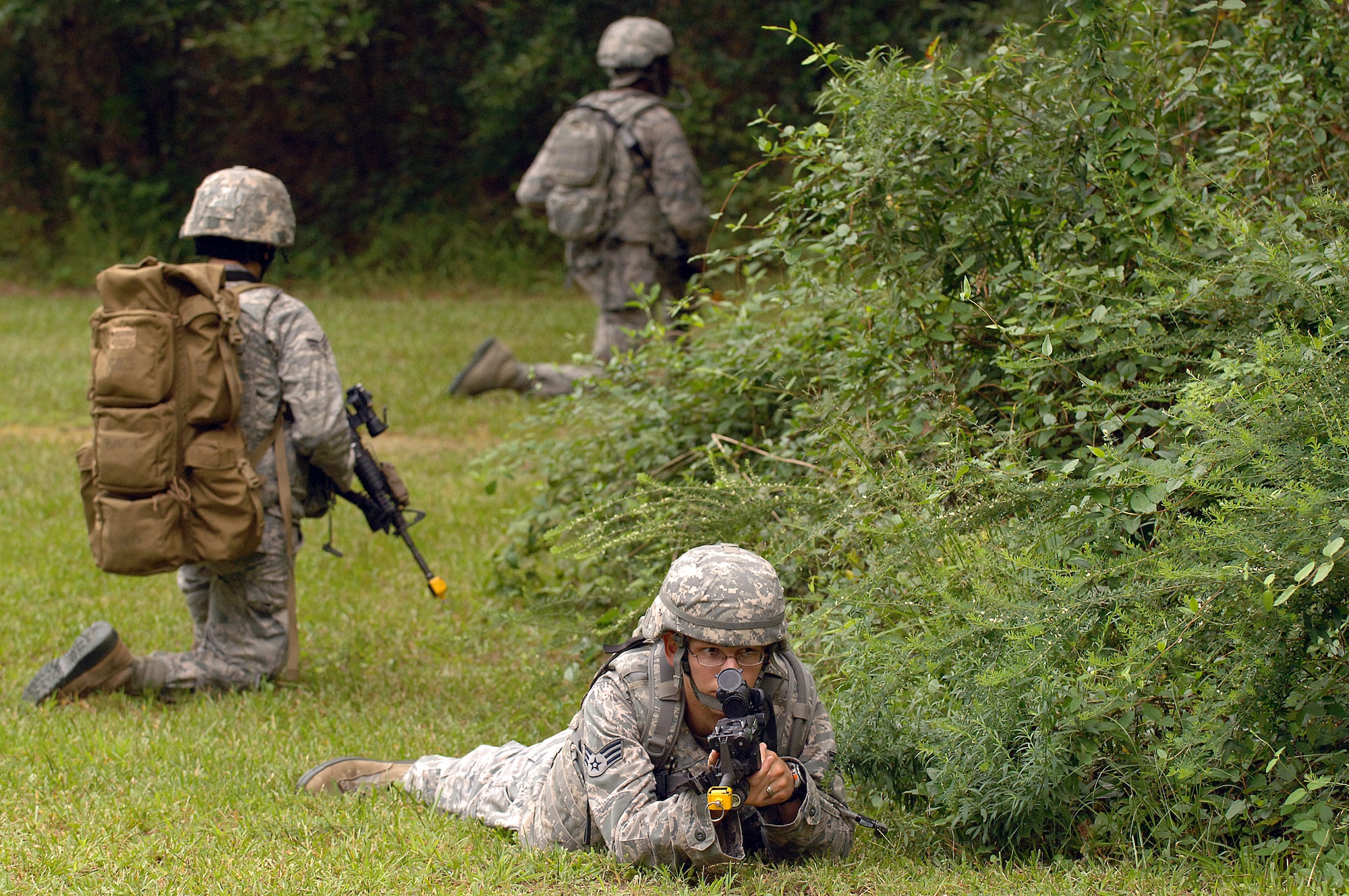 U.S. Air Force Senior Airman David Chrisner and Airmen 1st Class Brandon Santos and John Lightfoot, 4th Security Forces Squadron defenders, stand watch during an exercise at Seymour Johnson Air Force Base, N.C., Aug. 25, 2013.  The team kept an eye out for enemy hostiles prior to entering the woods to look for a weapons cache.  (U.S. Air Force photo by Airman 1st Class Brittain Crolley/Released)