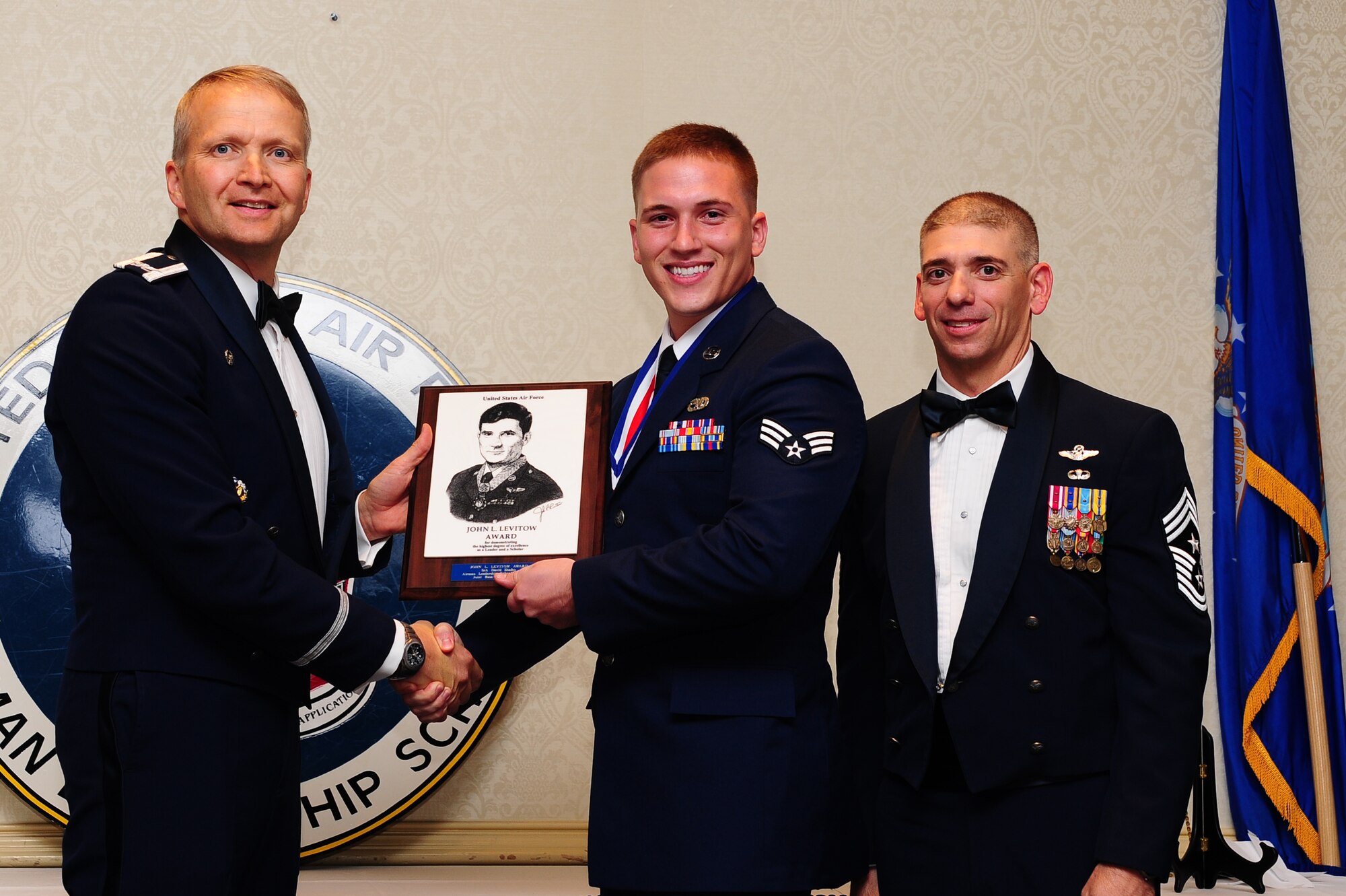 Col. Darren Hartford, 437th Airlift Wing commander, and Chief Master Sgt. Shawn Hughes, 437th Airlift Wing command chief, present Senior Airman David Shelby  , 437th Aircraft Maintenance Squadron crew chief, the John Levitow Award during the Airman Leadership School Class 13-F graduation ceremony Aug. 29, 2013, at JB Charleston - Air Base, S.C. The Levitow Award is awarded for a student's exemplary demonstration of excellence, both as a leader and scholar. (U.S. Air Force photo/ Airman 1st Class Chacarra Neal)